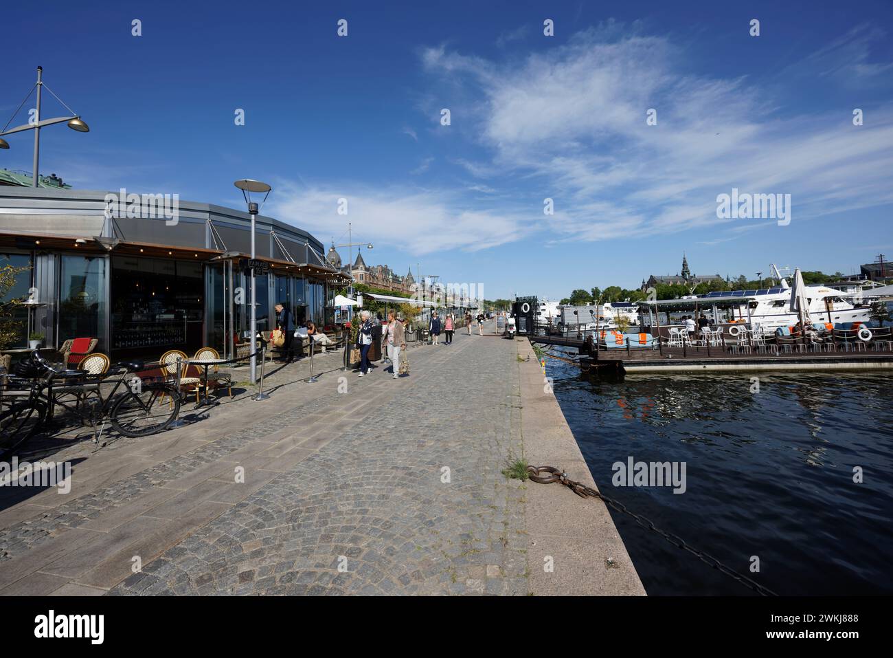 Auf der historischen Strandvagen-Uferpromenade spazieren die Menschen an Cafés, Bars und Booten im Ladugårdslandsviken-See, Ostermalm, Stockholm Stockfoto