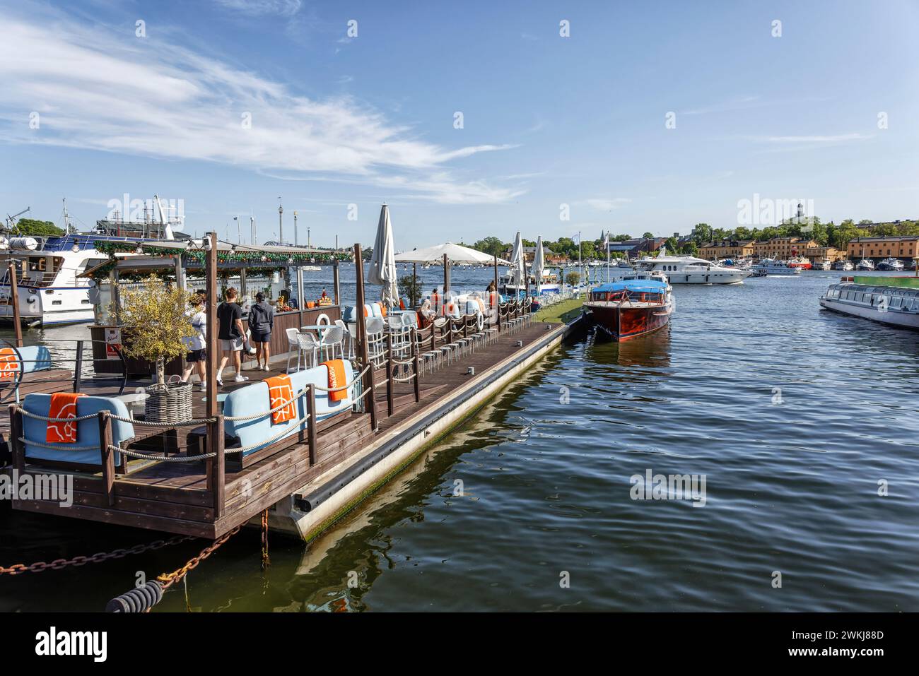 Menschen in Bars und Cafés am Wasser an der historischen Strandvagen Promenade am Ladugårdslandsviken See, Ostermalm, Stockholm Stockfoto