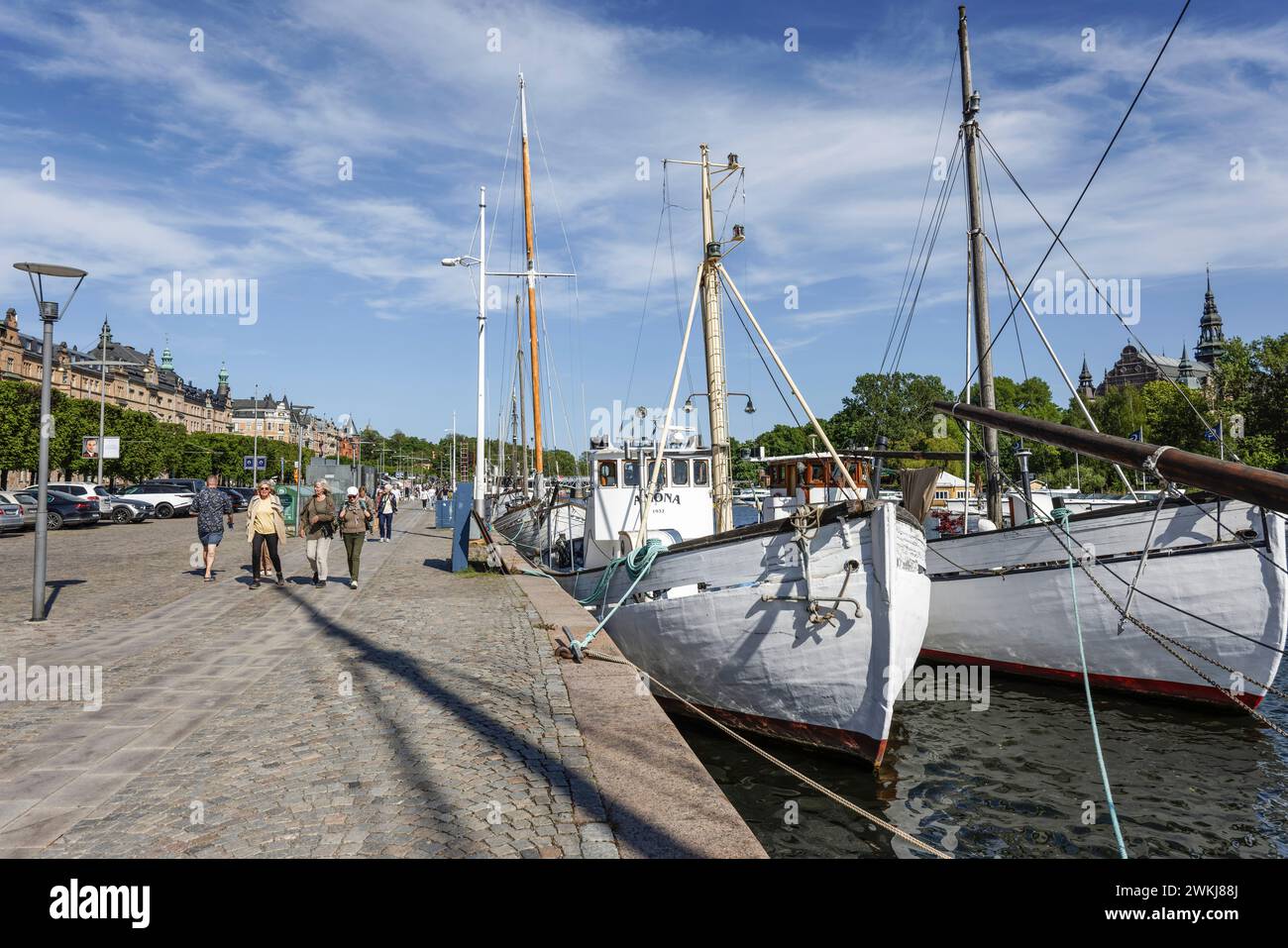 Auf der historischen Strandvagen-Uferpromenade spazieren die Menschen an Cafés, Bars und Booten im Ladugårdslandsviken-See, Ostermalm, Stockholm Stockfoto