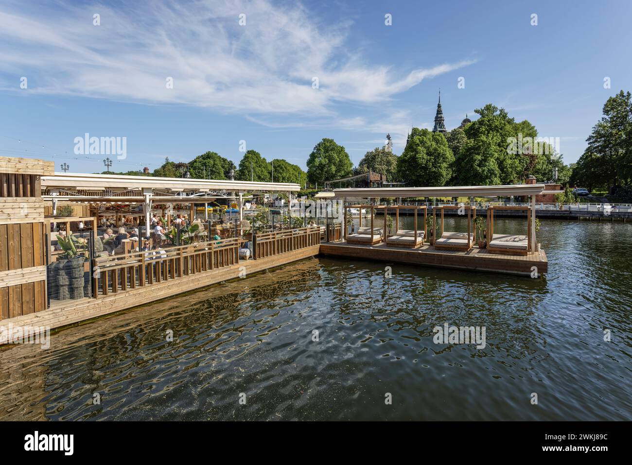 Menschen in Bars und Cafés am Wasser an der historischen Strandvagen Promenade am Ladugårdslandsviken See, Ostermalm, Stockholm Stockfoto
