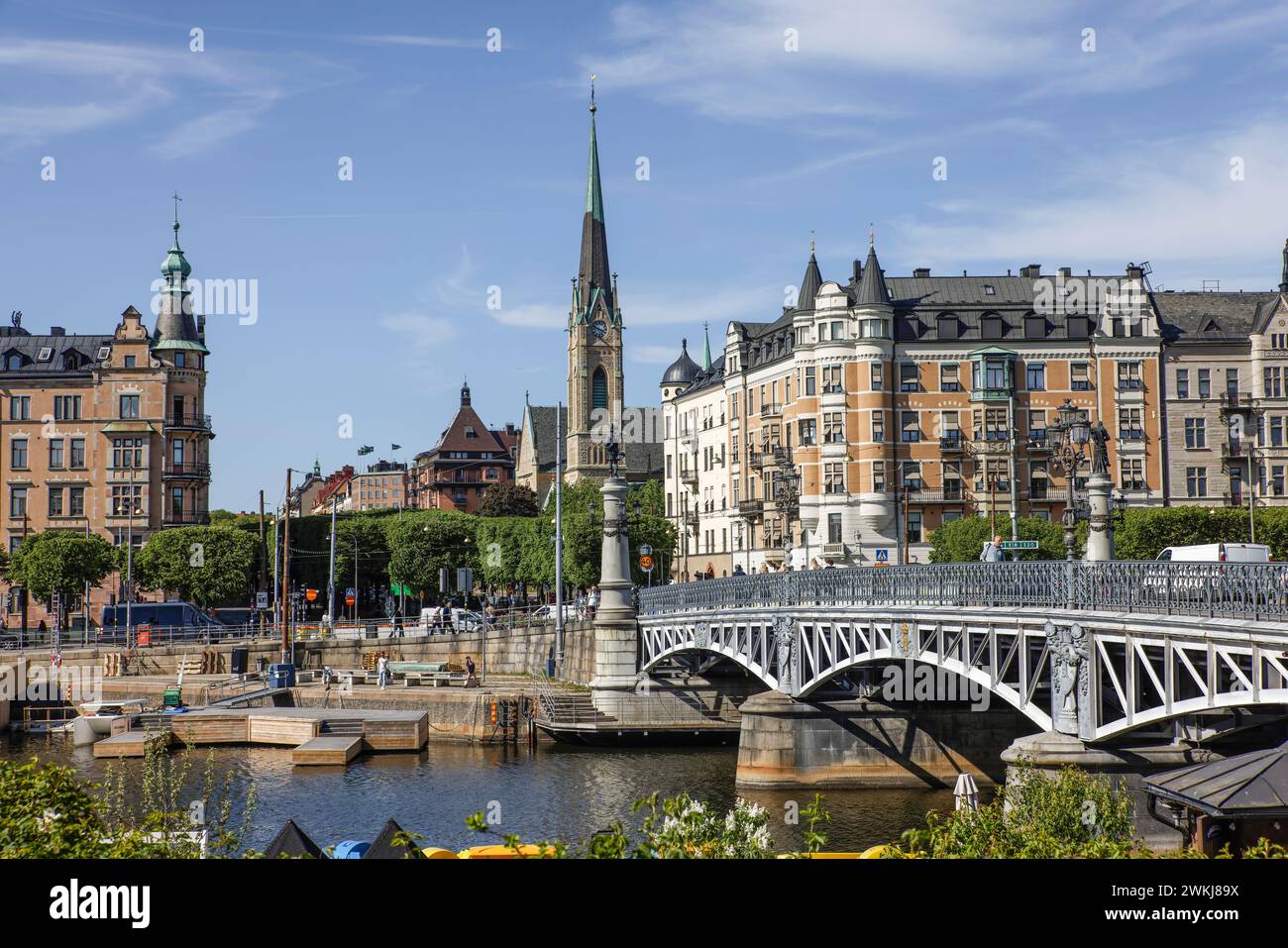 Djurgardsbron (Brücke) auf dem Strandvägen bewaldeten Boulevard durch Gebäude in Bajonetten (r) und Beväringen (l). Oscarskyrkan Kirche Ostermalm, Stockholm Stockfoto