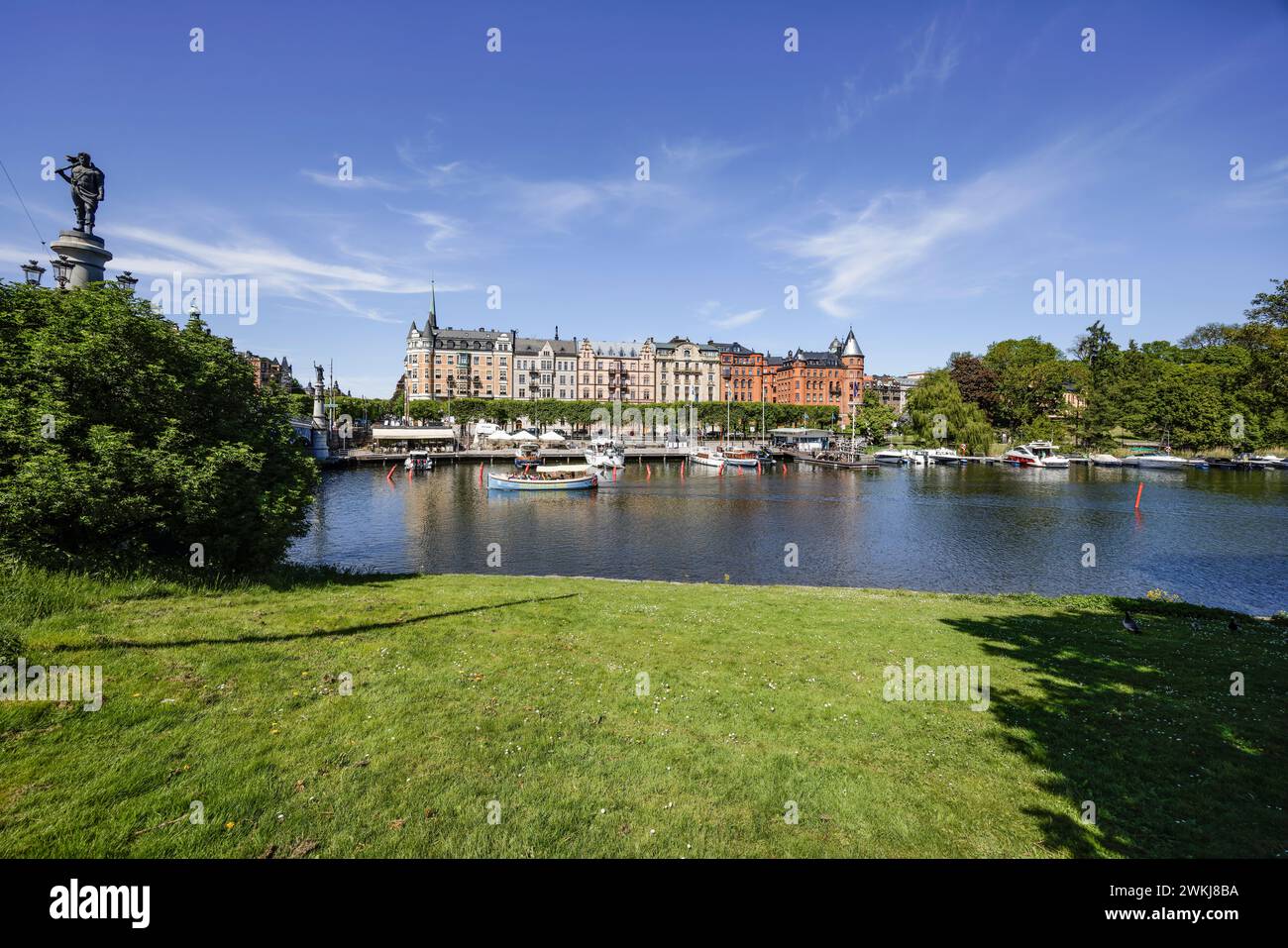 Boote, die an der Strandvägen-Kai-Promenade auf dem historischen, baumbestandenen Boulevard vor Anker liegen, an Gebäuden in Bajonetten-Gegend in Ostermalm, Stockholm. Stockfoto