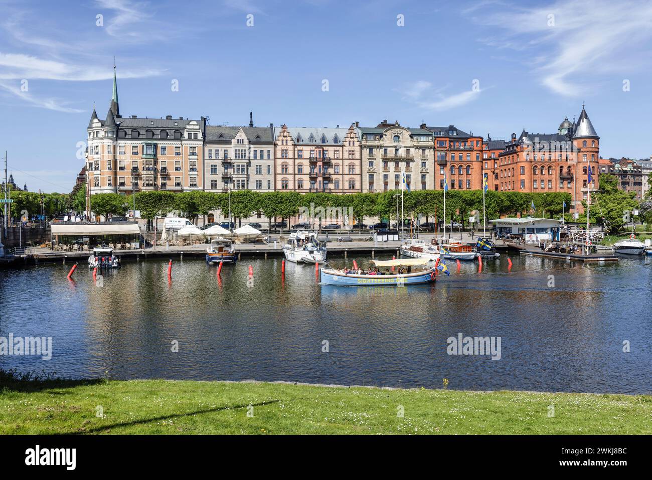 Boote, die an der Strandvägen-Kai-Promenade auf dem historischen, baumbestandenen Boulevard vor Anker liegen, an Gebäuden in Bajonetten-Gegend in Ostermalm, Stockholm. Stockfoto