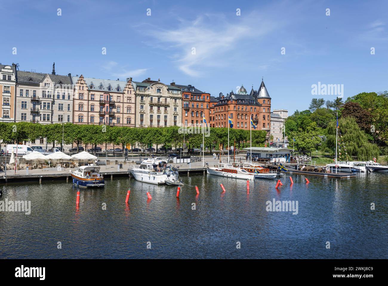 Boote, die an der Strandvägen-Kai-Promenade auf dem historischen, baumbestandenen Boulevard vor Anker liegen, an Gebäuden in Bajonetten-Gegend in Ostermalm, Stockholm. Stockfoto