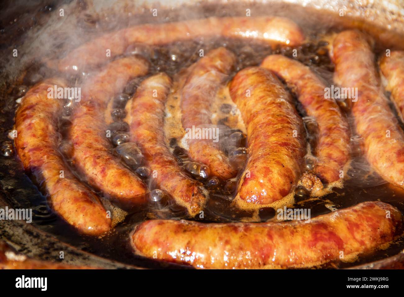 Street Food Kochen auf großer Pfanne, leckere hausgemachte Würstchen auf großer kommerzieller Grillplatte, Food Festival auf der Landseite Serbiens Stockfoto