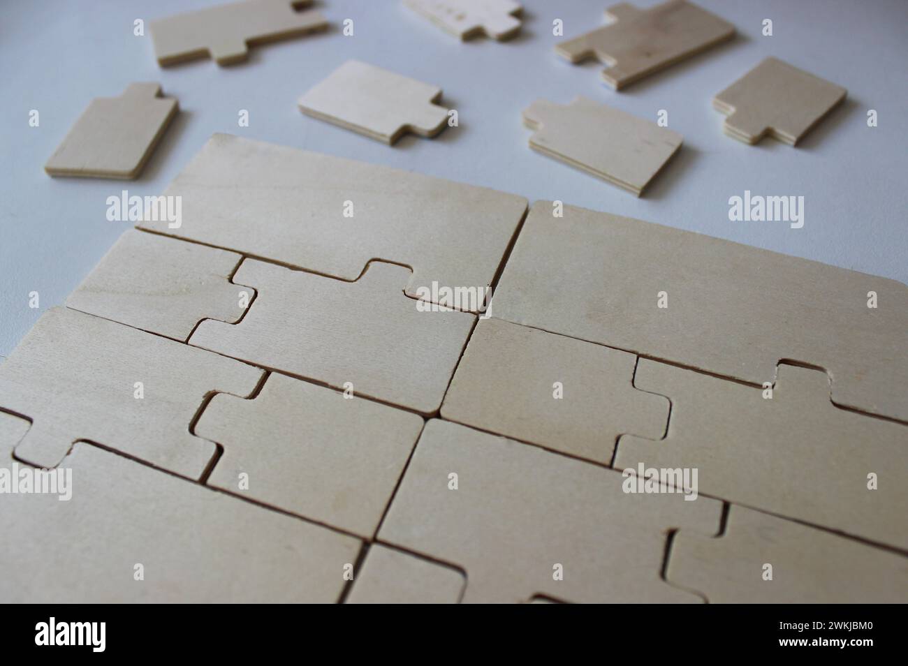 Ein Rechteck mit gefalteten Holzpuzzles und einer Reihe zusätzlicher Elemente in der Nähe Stockfoto