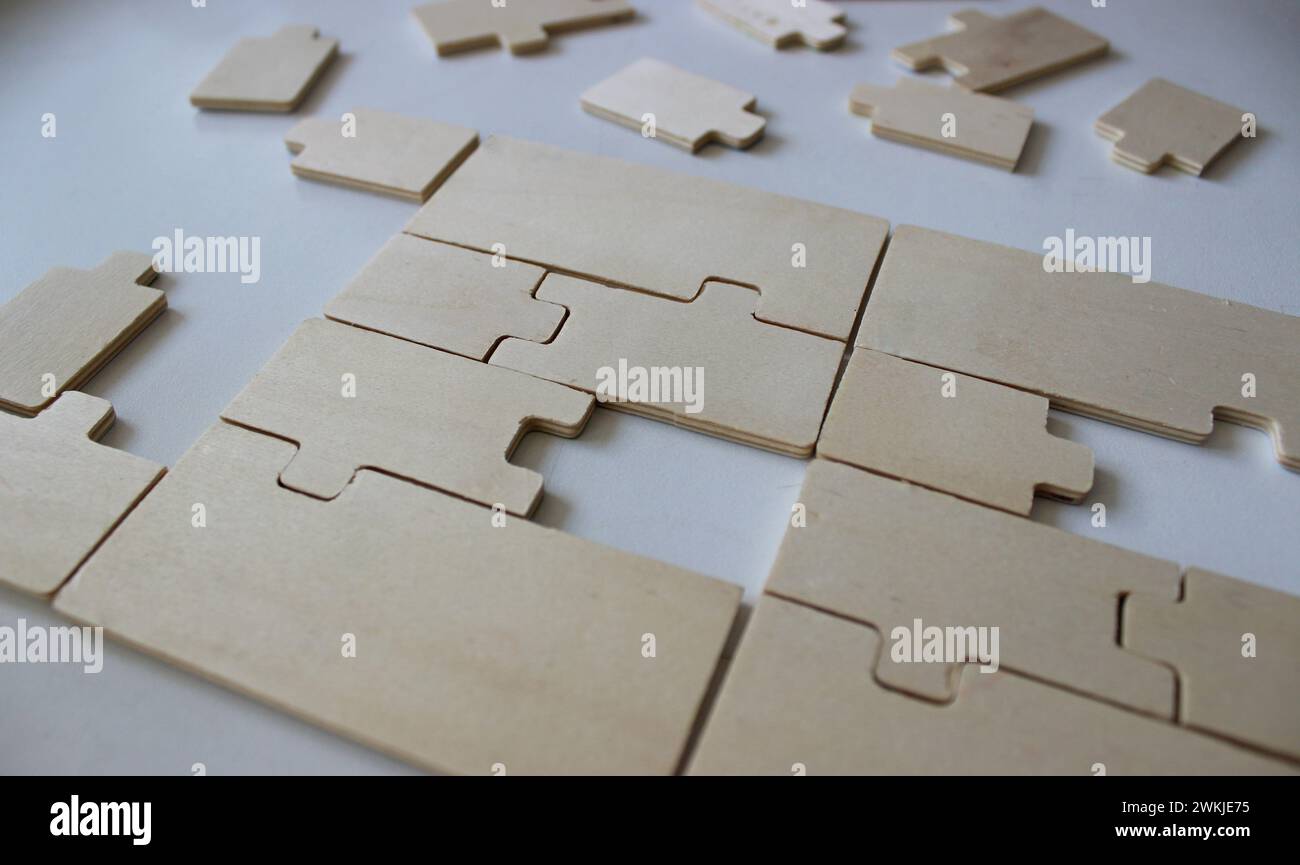 Zerlegtes rechteckiges Paneel aus Sperrholzpuzzles und einem Satz zusätzlicher Elemente Stockfoto