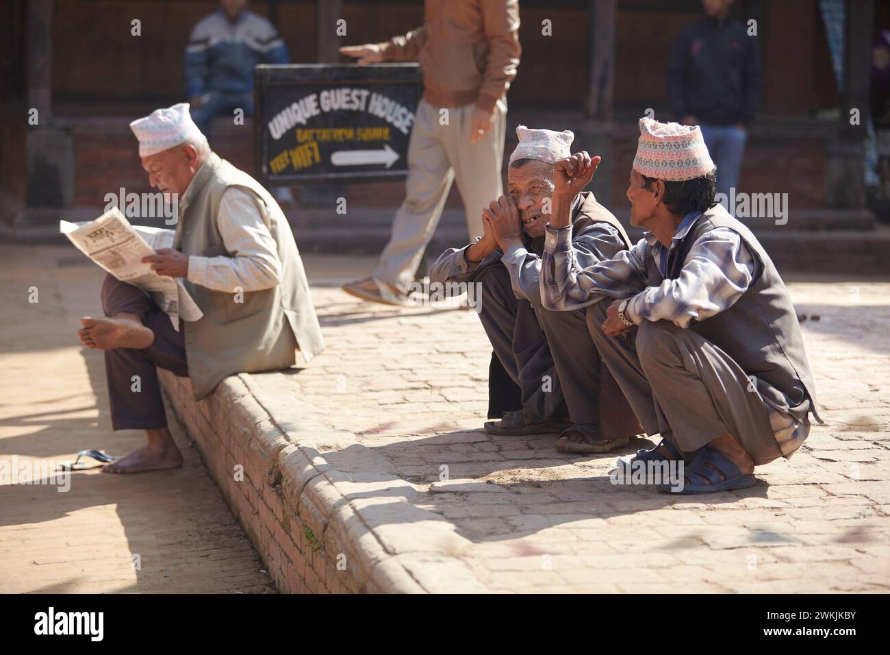 Nepalesen mit traditionellen Hüten (Dhaka Topi oder Nepali Topi) unterhalten sich in einer Straße von Kathmandu, Nepal. Stockfoto