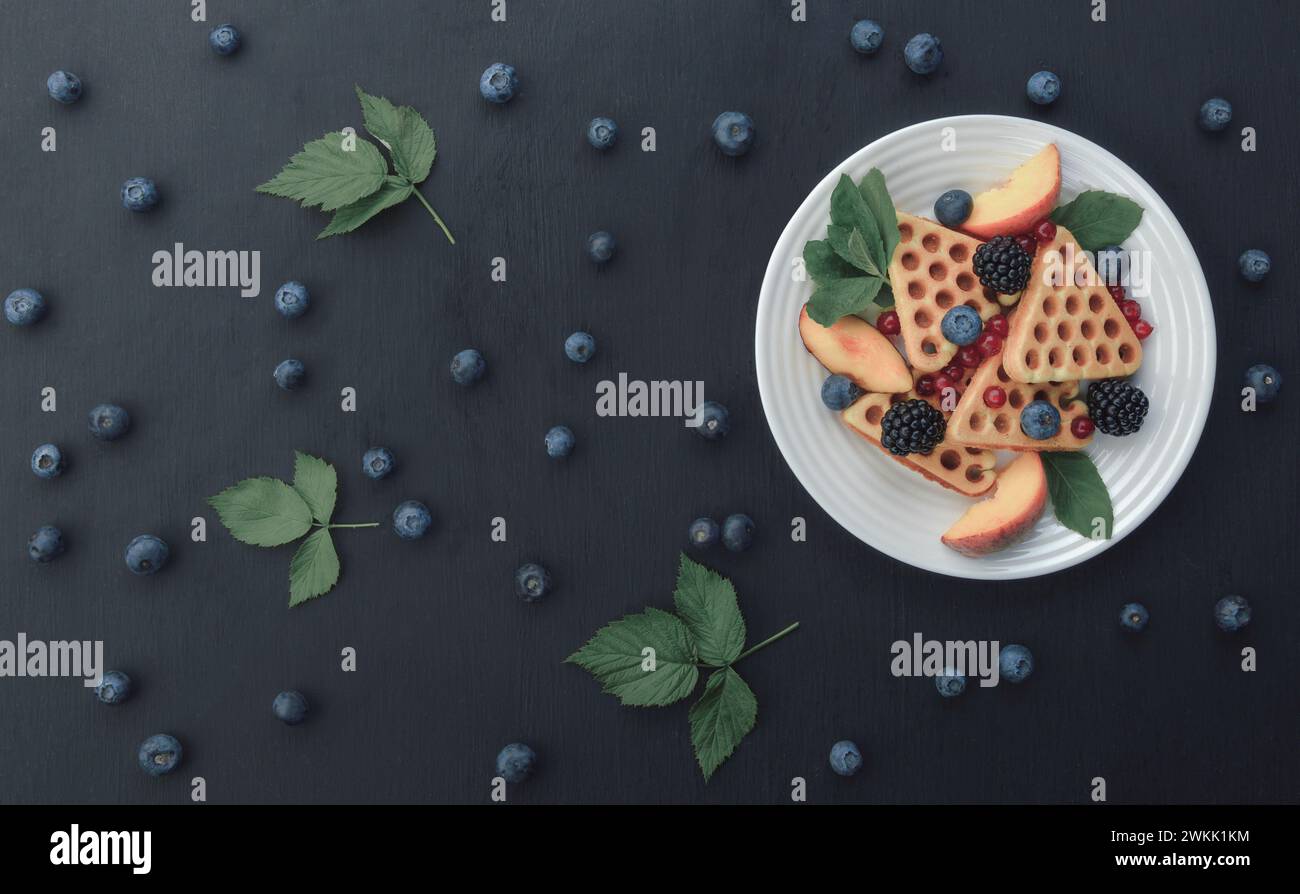 Stapel belgischer Waffeln mit Heidelbeere und Honig zum Frühstück. Köstliches hausgemachtes Gebäck. Waffeln mit Himbeeren, Heidelbeeren, Sauerrahm und Hone Stockfoto