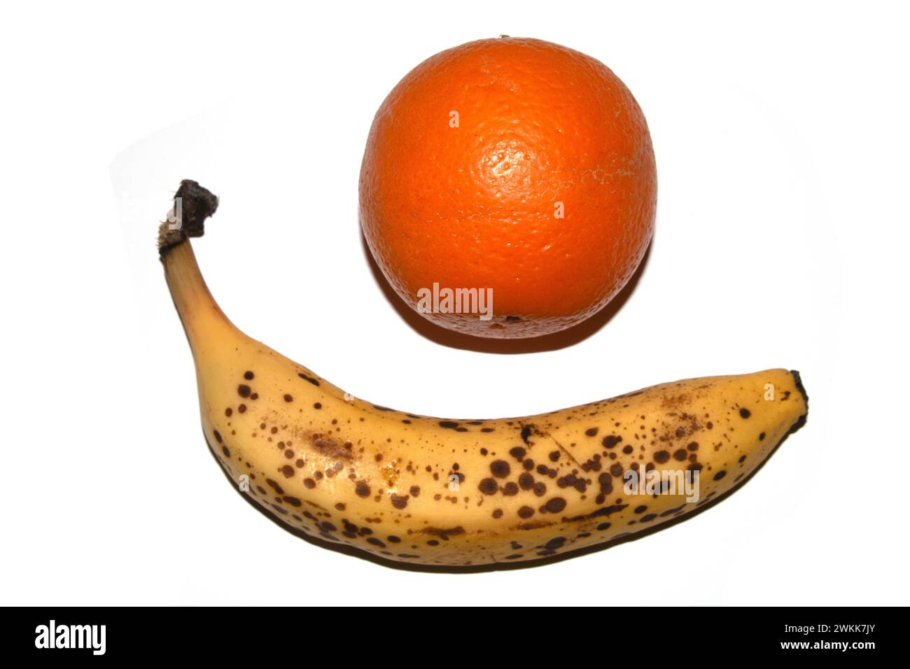 Eine überreife Banane auf ihrer Haut auf einer weißen Backfrucht Stockfoto