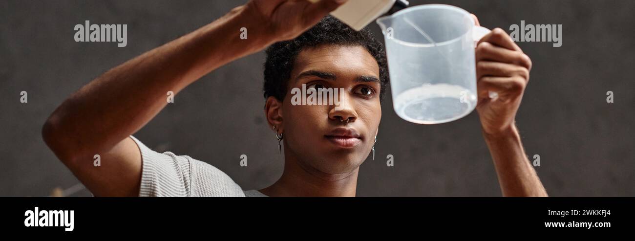 Schöner afroamerikanischer Mann, der chemische Lösung in den Messbecher gießt, Banner der Filmentwicklung Stockfoto