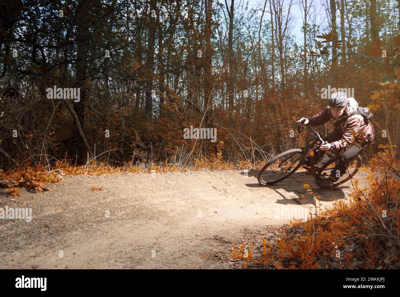 Radfahrer auf einem Schotterrad fahren entlang einer scharfen Kurve auf einem Pfad im Wald. Extremsport. Stockfoto