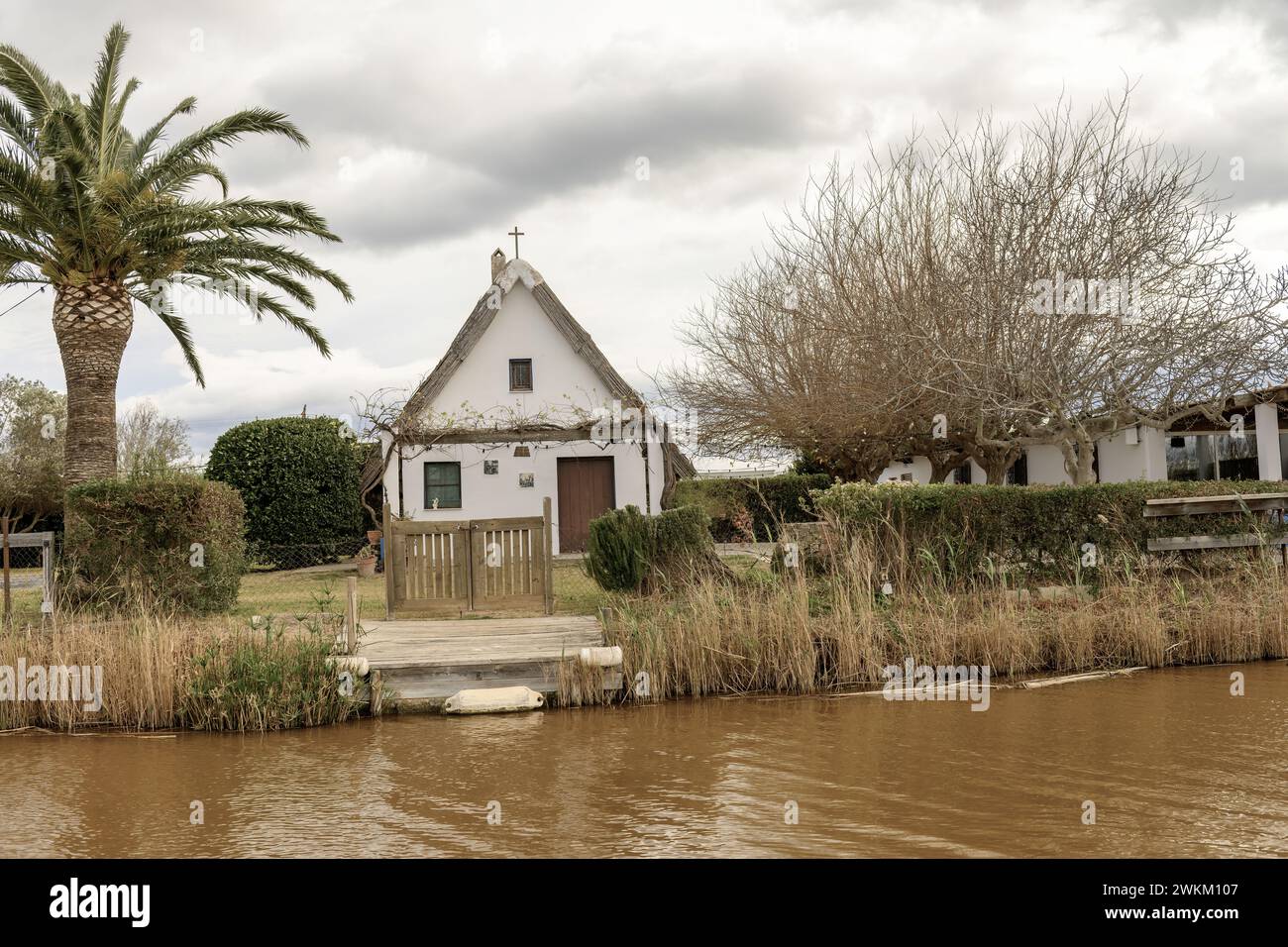 Ein charmantes Reetdachhaus steht am Ufer im Albufera Naturpark in der Nähe von Valencia und bietet einen ruhigen ländlichen Rückzugsort. Stockfoto