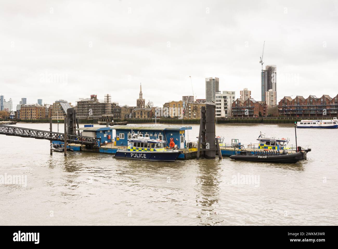 Die Boote der Wasserpolizei auf der Themse liegen am Ponton der Wapping Police und am Pier mit der St. Mary's Church, Rotherhithe im Hintergrund. Stockfoto