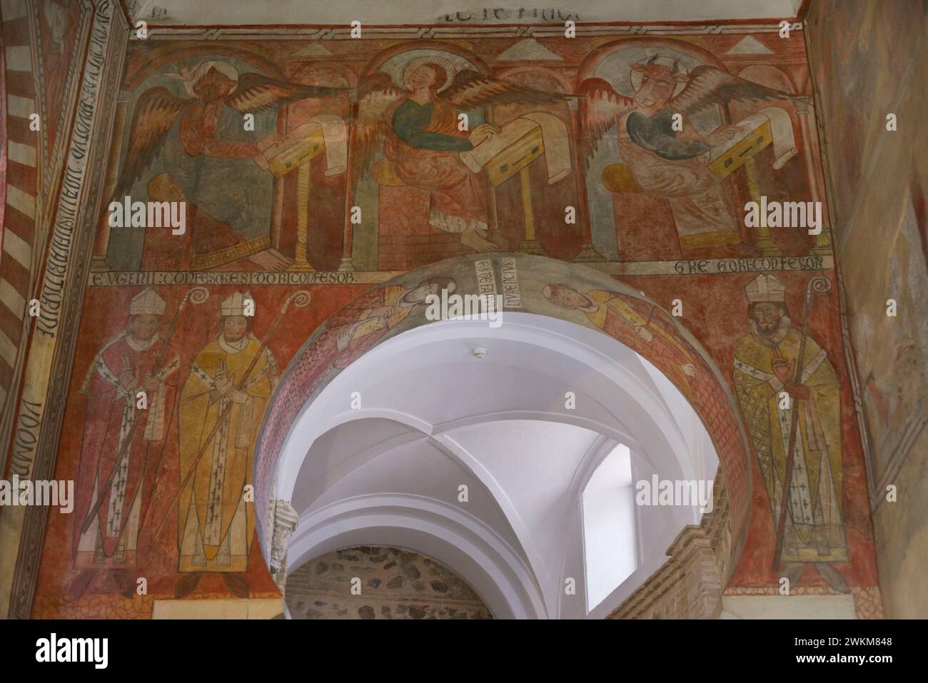 Spanien, Toledo. Kirche San Román. Erbaut im Mudéjar-Stil im 13. Jahrhundert. Gemälde an der Ostfassade des Kirchenschiffs. Im oberen Teil: St. Matthäus, St. Markus und St. Lukas, drei der Evangelisten. Sie werden geflügelt dargestellt und mit ihrem Zoomorphsymbol, wie sie die Evangelien schreiben, verändert. Im unteren Teil befinden sich drei Bekenner der katholischen Kirche: Der heilige Eugen, der heilige Isidor und der heilige Gregor. Stockfoto