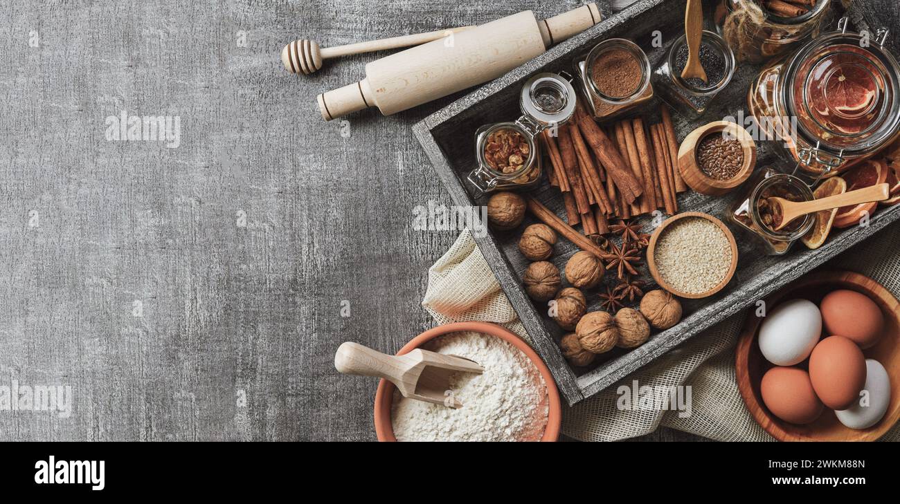 Baking Love. Backwarenhintergrund. Backzutaten und Küchenutensilien auf schwarzem Hintergrund. Mehl, Mandelnüsse, Eier. Draufsicht. Moderne Küche Stockfoto