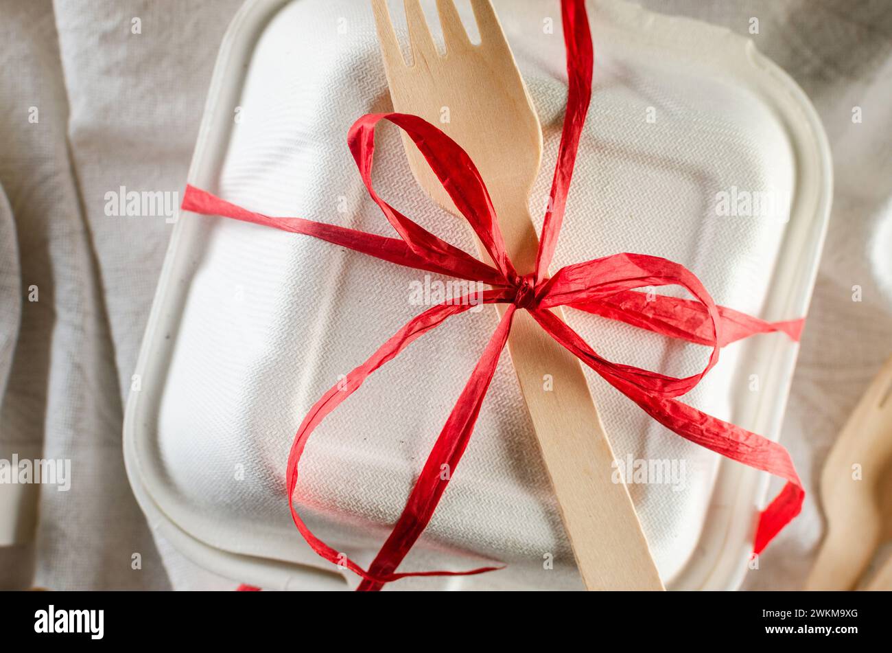 Weiße bento-Kuchenbox mit roter Schleife. Geschenkbox mit leckerem bento. Kuchenverpackung. Lieferung. Stockfoto