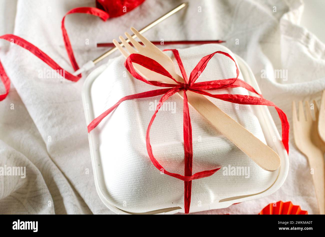 Weiße bento-Kuchenbox mit roter Schleife. Geschenkbox mit leckerem bento. Kuchenverpackung. Lieferung. Stockfoto