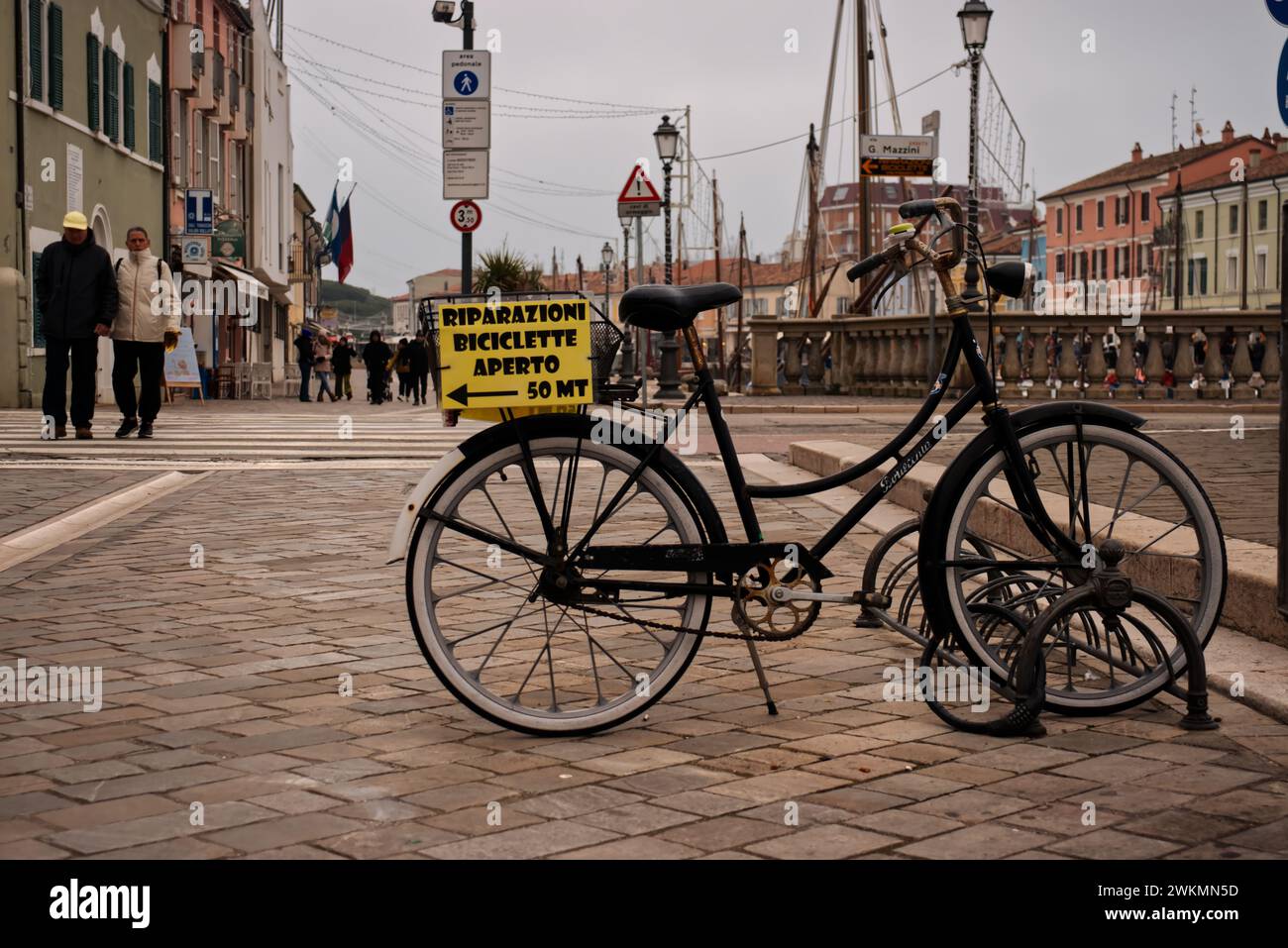 CESENATICO, ITALIEN 2. JANUAR 2024: Ein altes Fahrrad parkt auf der Straße des Hafens von Cesenatico, Italien. Stockfoto