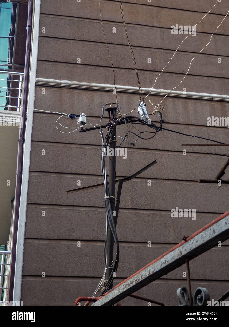 Hausgemachte Stromstange aus Metall. Drähte an einem Stab. Strom auf der Straße. Konzept Stockfoto