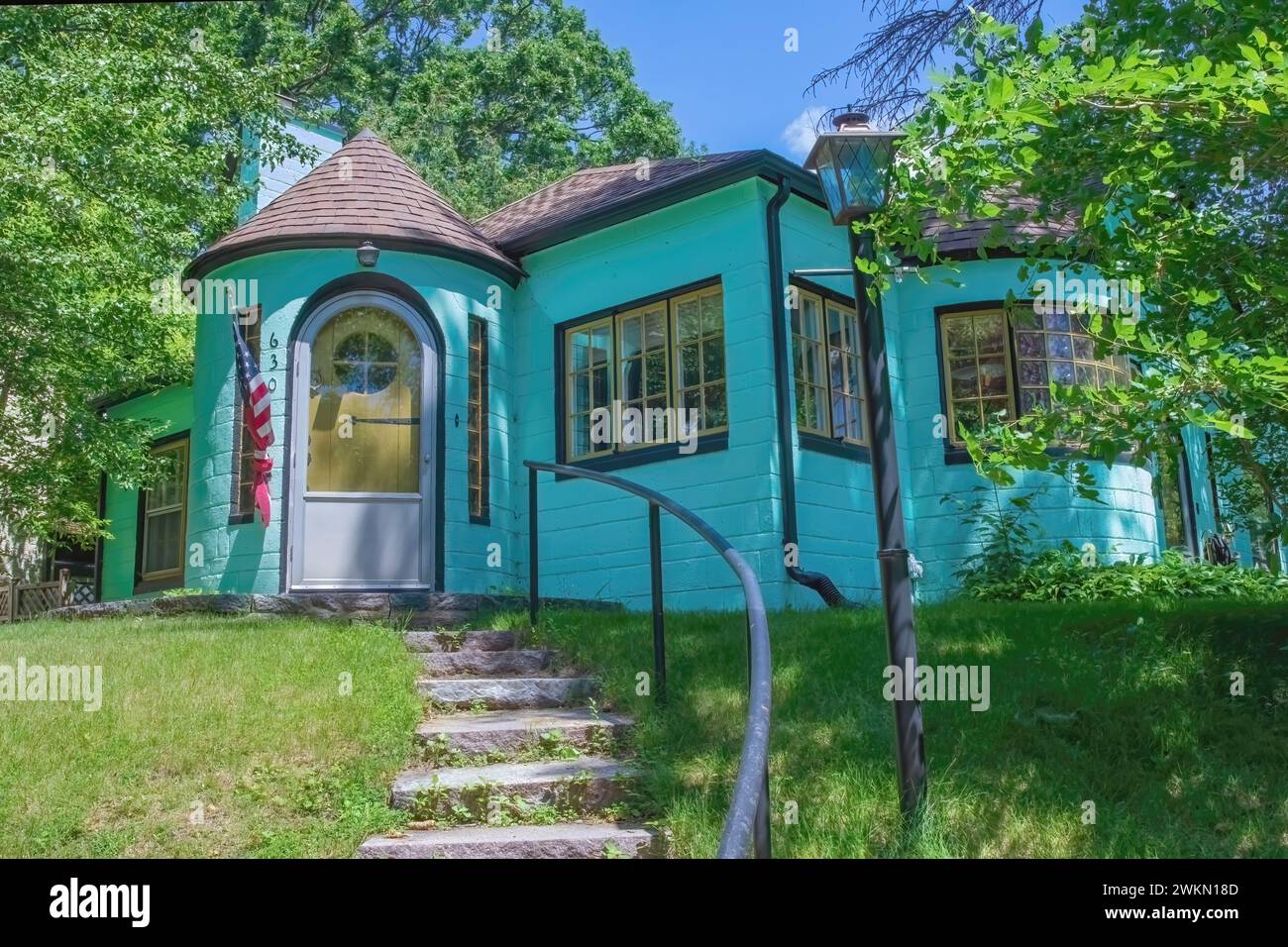 Interessantes, mintgewächstes Haus, das „Barbie House“ genannt wird, mit einem Türbereich und gepflegten Fenstern auf einem Hügel in St. Cloud, Minn. Stockfoto
