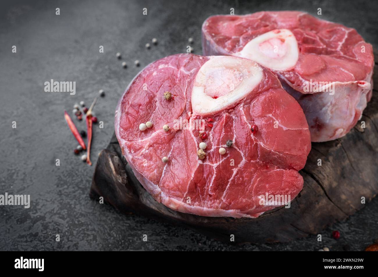 Ossobuco. Rohe Rindersobuco-Steak, italienischer Osobuco mit Kochgewürzen. Schwarzer Hintergrund. Draufsicht. Stockfoto