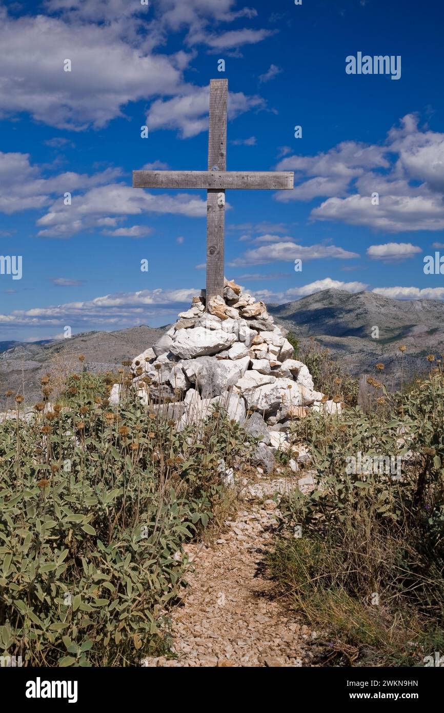 Pfad führt zum Holzkreuz in einem Haufen von gestapelten Felsen, Mount SRD, Dubrovnik, Dalmatien Region, Kroatien. Stockfoto