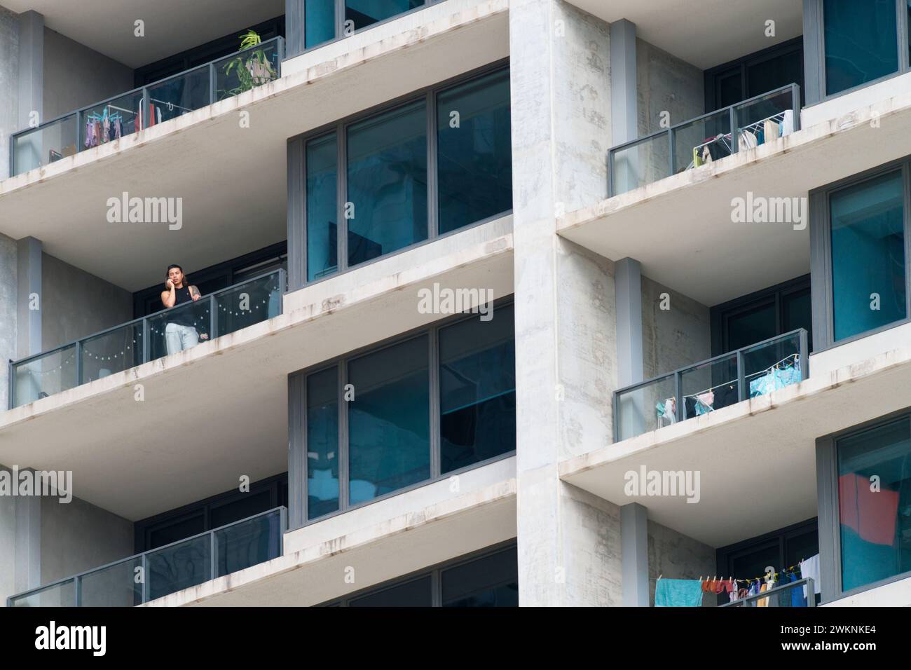 Person, die zu Hause telefoniert, in einem Apartmentgebäude mit Balkonen und mehreren Wohnungen, Melbourne, Australien. Stockfoto