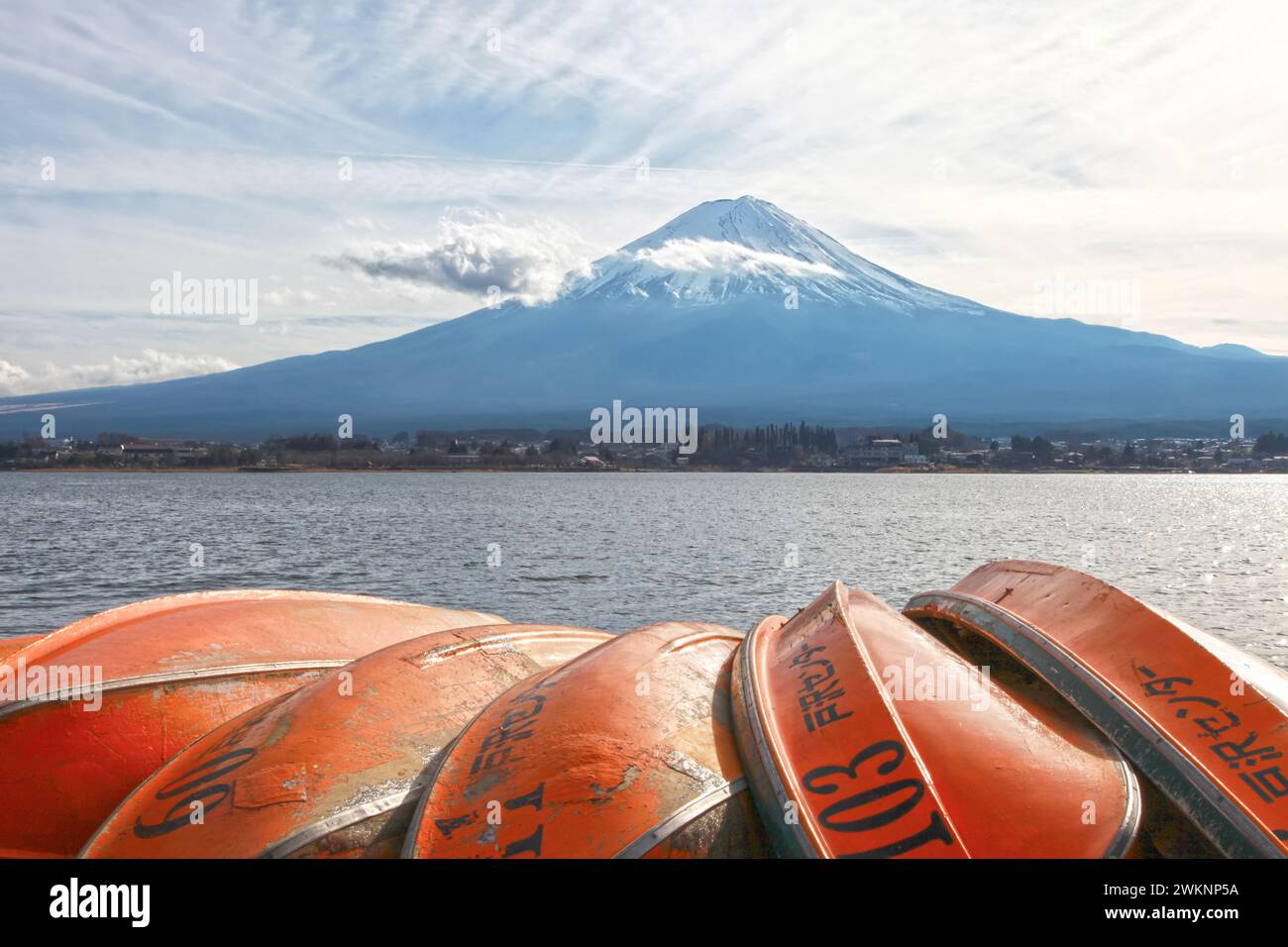 Kawaguchi-See mit Mt. Fuji im Hintergrund und mehrere orangefarbene Boote im Vordergrund. Stockfoto