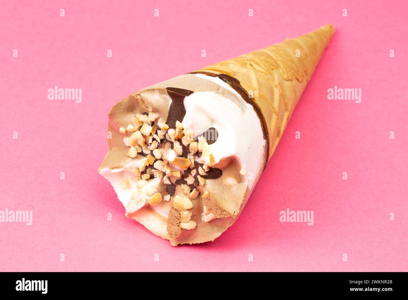 Schokoladen- und Vanilleeis in einem Waffelkegel auf rosafarbenem Hintergrund Stockfoto