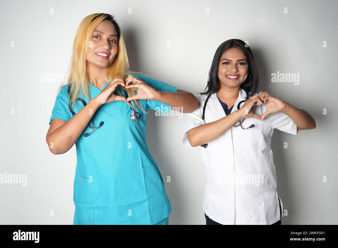 Zwei weibliche Ärzte, die mit ihren Händen eine Herzform bilden Stockfoto