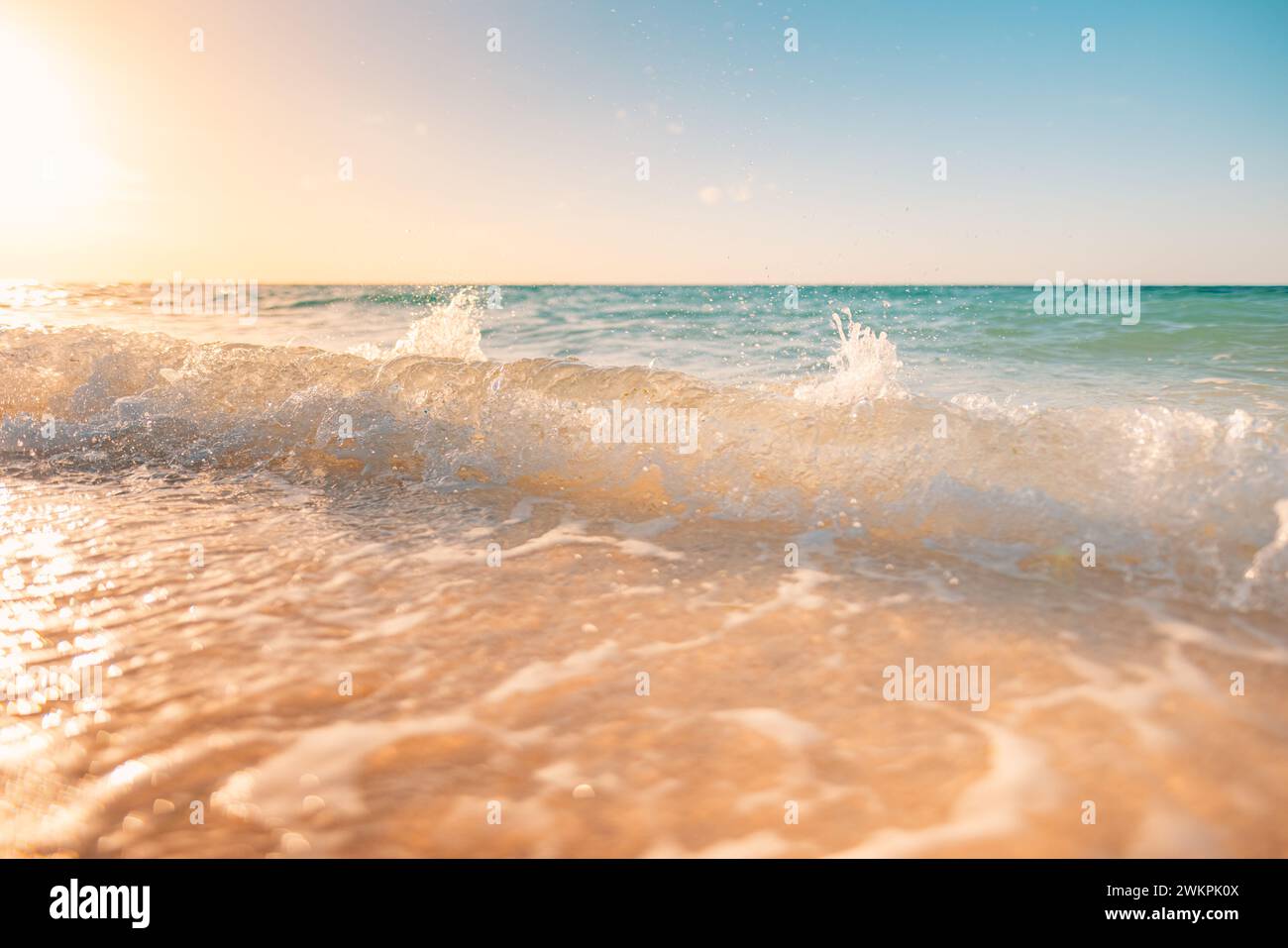 Fantastischer Blick aus der Nähe auf die ruhigen Meerwasserwellen mit orangefarbenem Sonnenaufgang Sonnenuntergang. Meditation an der Inselküste, Inspiration friedlich. Sommerurlaub, ho Stockfoto