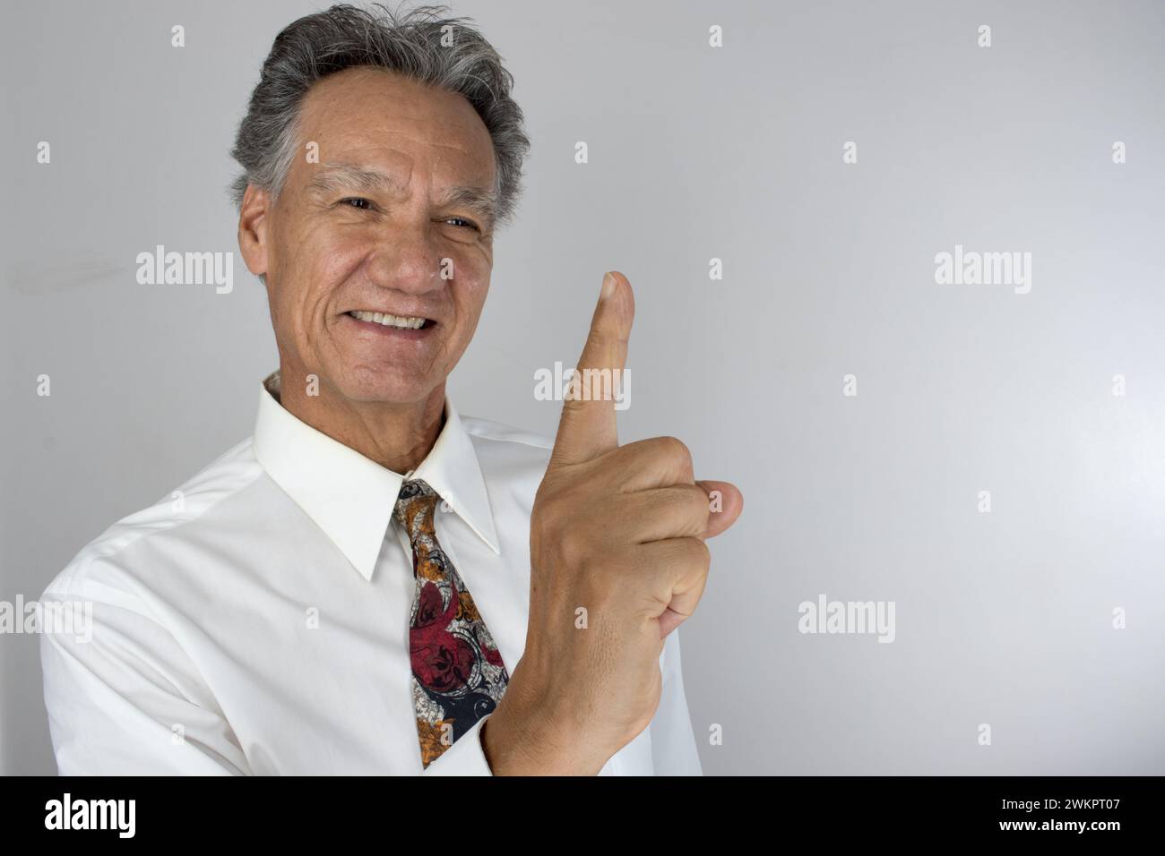 Ein älterer Mann, der glücklich die Nummer eins mit dem Finger macht Stockfoto