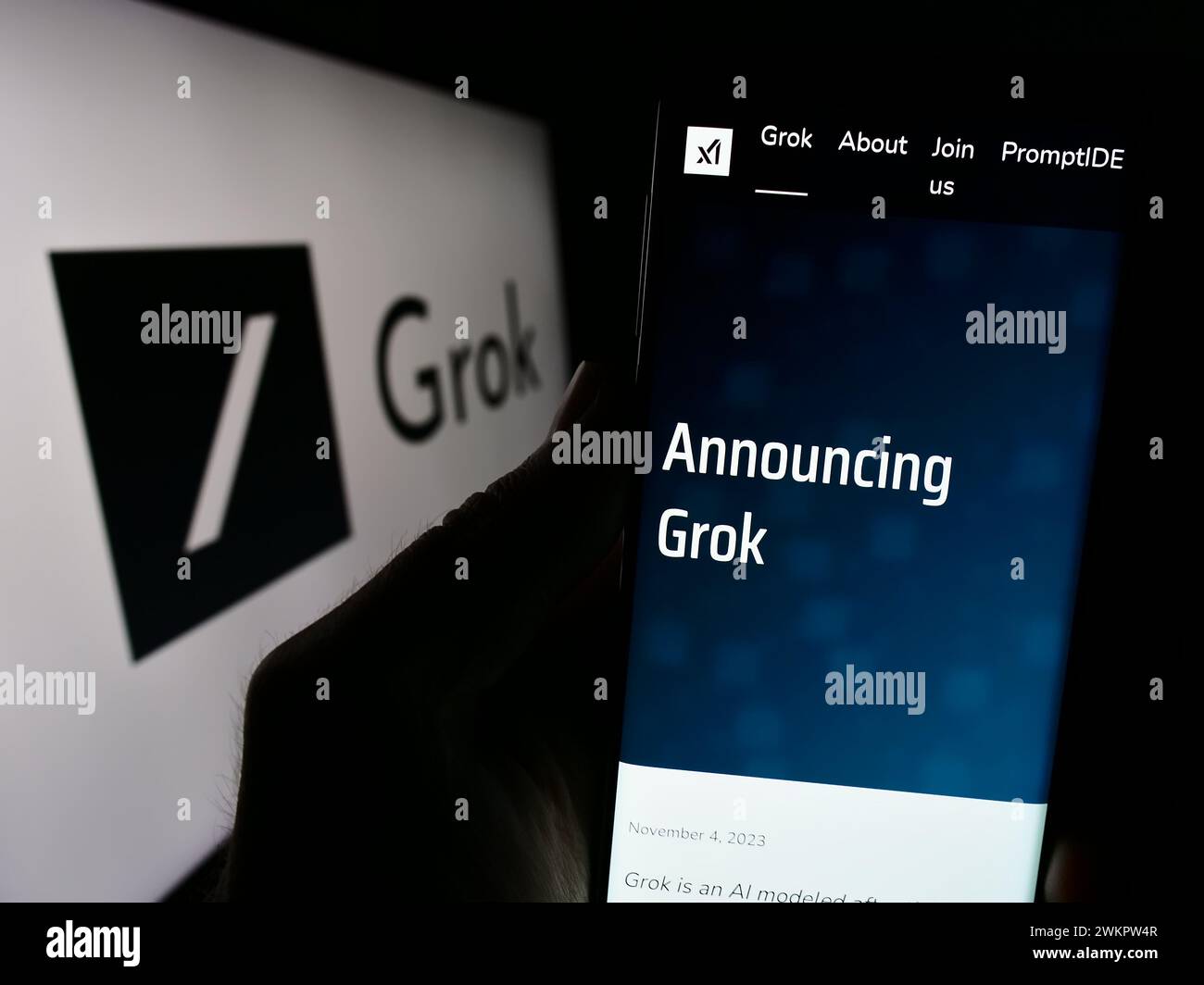Person, die ein Smartphone mit Website des Chatbots Grok (X.AI) mit Logo hält. Konzentrieren Sie sich auf die Mitte des Telefondisplays. Stockfoto