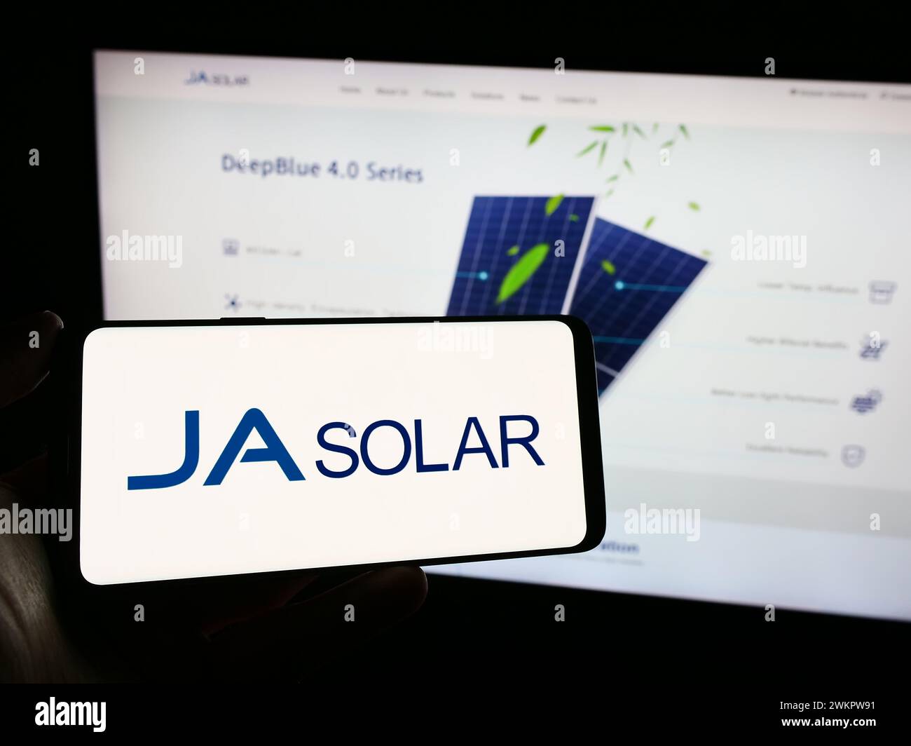Person, die ein Mobiltelefon mit dem Logo des chinesischen Unternehmens ja Solar Holdings Co. Ltd. Vor der Business-Webseite hält. Schwerpunkt auf dem Display des Telefons. Stockfoto