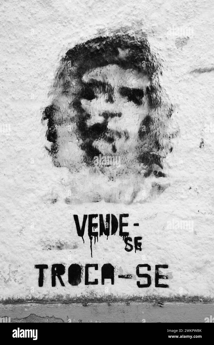 Tomar, Portugal - 28. April 2015: Che Guevara Graffiti an der alten Hauswand und Text auf Portugiesisch „zum Verkauf, zum Austausch“. Stockfoto