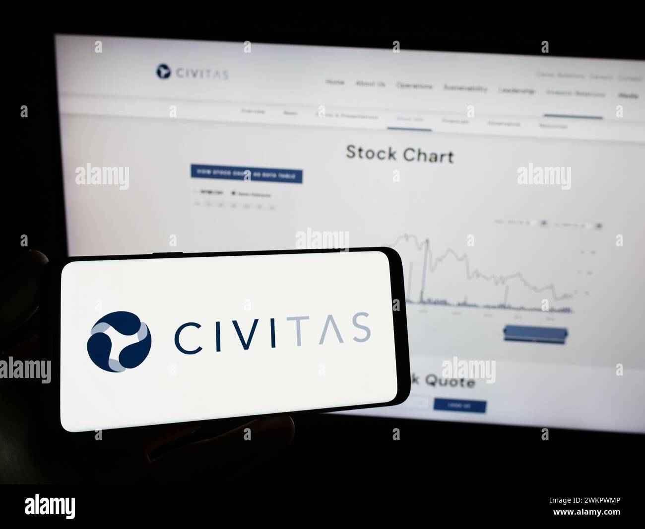 Person, die ein Mobiltelefon mit dem Logo des amerikanischen Öl- und Gasunternehmens Civitas Resources Inc. Vor der Webseite hält. Schwerpunkt auf dem Display des Telefons. Stockfoto