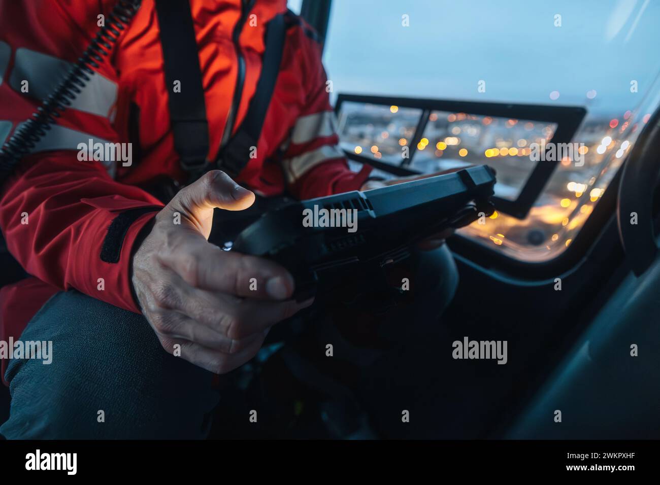 Nahaufnahme der Hände des Arztes im Hubschrauber-Notdienst bei Verwendung eines digitalen Tablets während eines Nachtmission Fluges. Stockfoto
