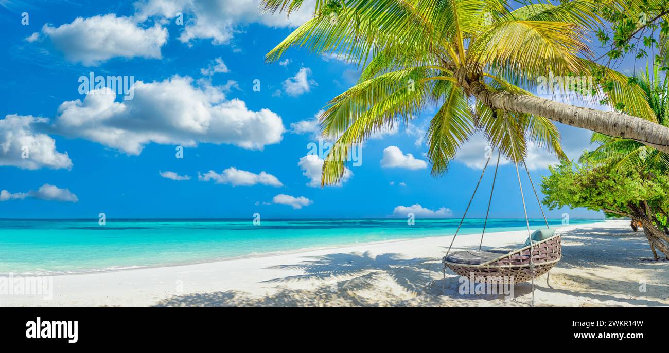 Tropischer Strandhintergrund, während im Sommer die Landschaft mit Strandschaukel oder Hängematte und weißem Sand und ruhigem Meer als Strandvorlage entspannt wird. Fantastische Strandszene Stockfoto