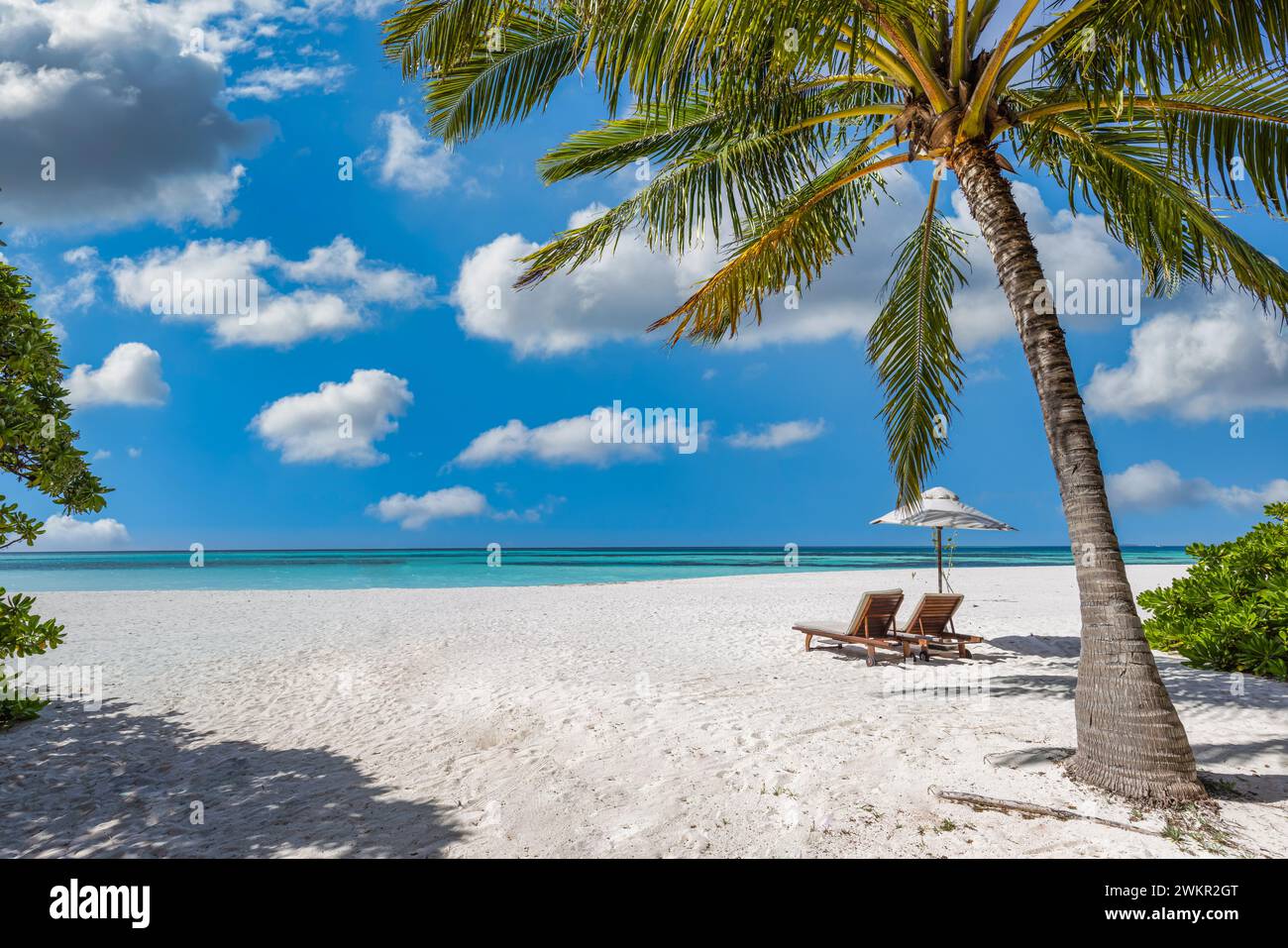 Wunderschöner Meersanduft. Tropischer Relax Strand sonnige Sommerinsellandschaft. Liebe Paar Stühle Sonnenschirm Palme Blätter romantische Küste. Luxuriöse Freizeit Stockfoto