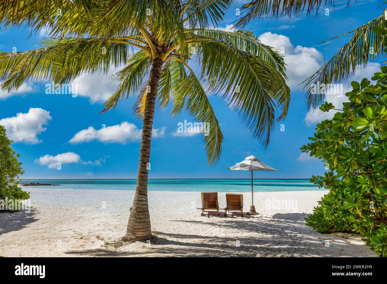 Wunderschöner Meersanduft. Tropischer Relax Strand sonnige Sommerinsellandschaft. Liebe Paar Stühle Sonnenschirm Palme Blätter romantische Küste. Luxuriöse Freizeit Stockfoto