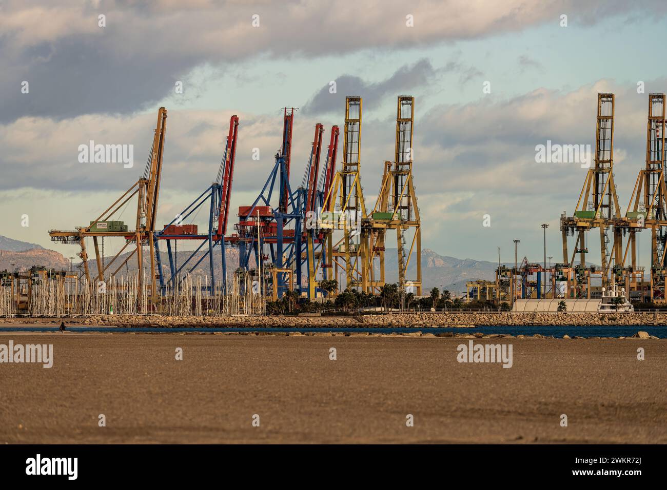 Ein geschäftiger Industriehafen zeigt die Aktivität des Handels mit Containerkränen, die bereit sind, Fracht von Containerschiffen zu be- und entladen. Stockfoto