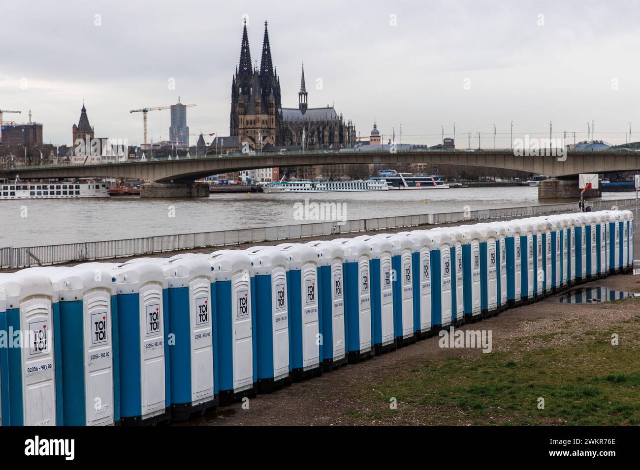 Eine große Anzahl von porta-Töpfchen befindet sich nach den Karnevalstagen in der Deutzer Werft, Rheinufer im Stadtteil Deutz, Blick auf den Dom, Stockfoto