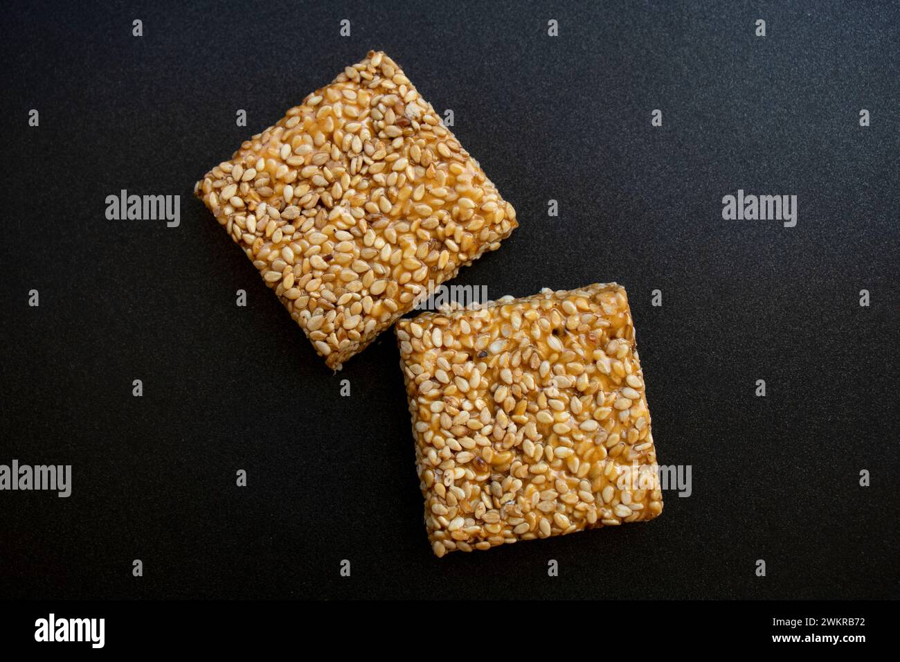 Bis Chikki auf schwarzgrauem Hintergrund. Till Chikki ist ein indisches Süßwarengericht, das mit Jaggery und Sesam zubereitet wird. Indisches Festival makar sankranti besonderes Süßes Stockfoto