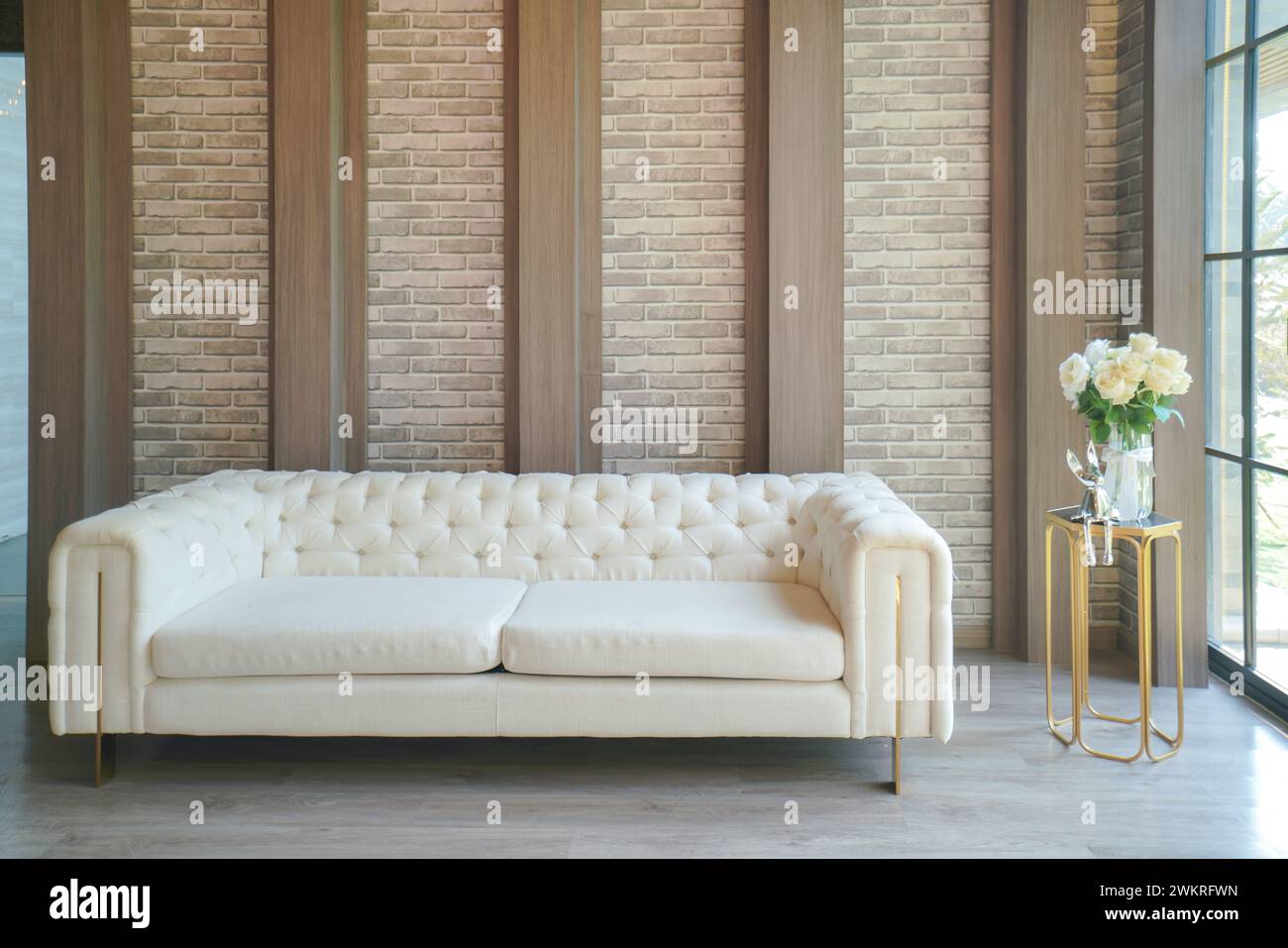 Erleben Sie die Fusion aus Komfort und Stil in diesem schicken Wohnbereich. Das Herzstück, ein luxuriöses weißes Sofa, bietet einen einladenden Raum zum Entspannen. Text Stockfoto