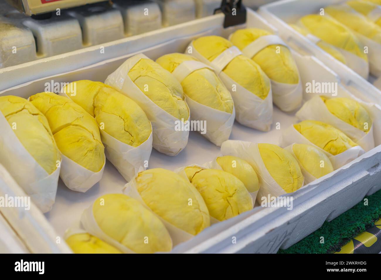 Frisch geschälte Durianfrüchte, bekannt als der „König der Früchte“, ordentlich in Frischhaltefolie verpackt und zum Verkauf ausgestellt Stockfoto