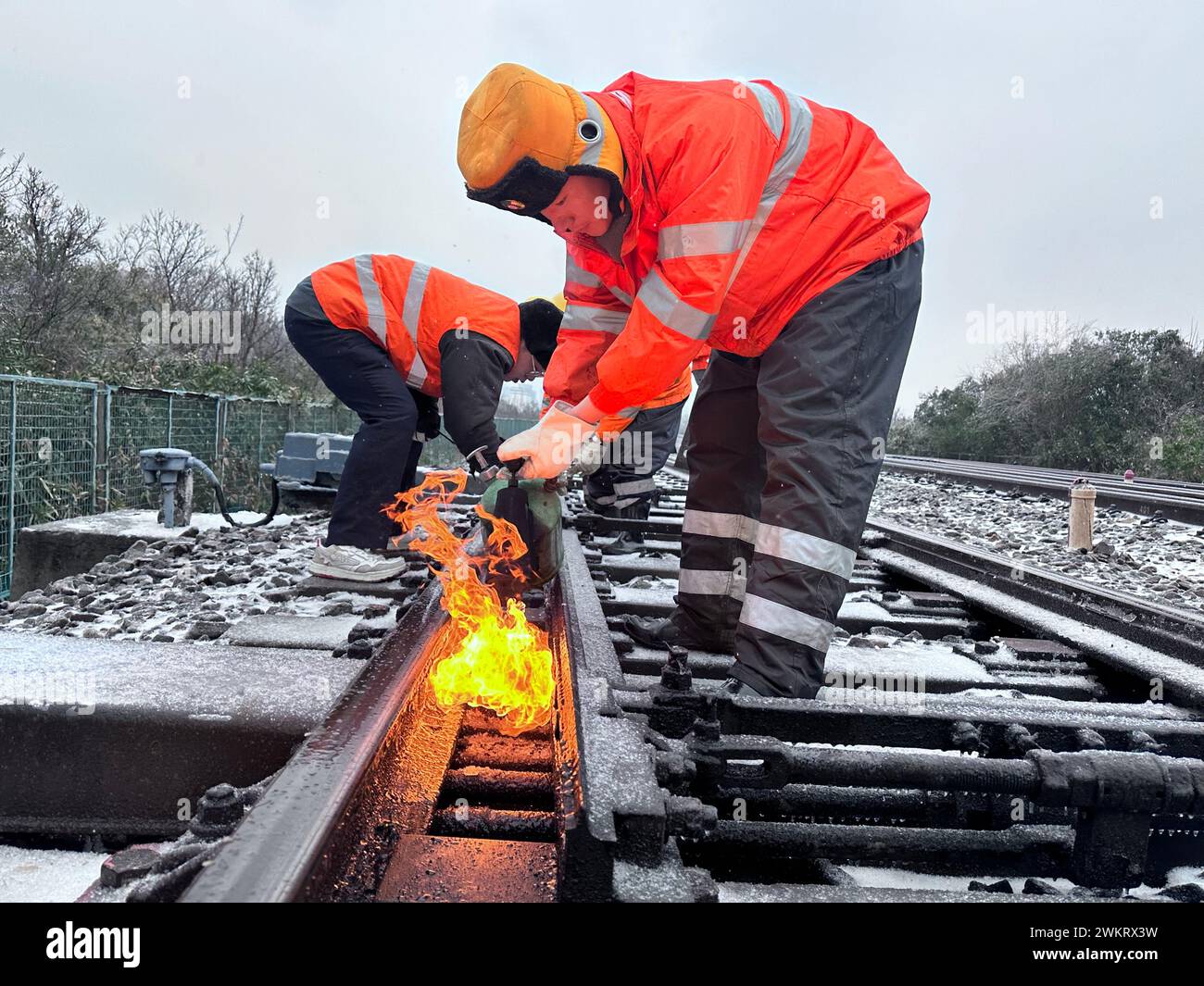 JIUJIANG, CHINA - 22. FEBRUAR 2024 - Arbeiter schmelzen Eis in einem Schaltbereich des Lushan-Abschnitts der Peking-Kowloon-Eisenbahn in Jiujiang, Provinz Jiangxi Stockfoto