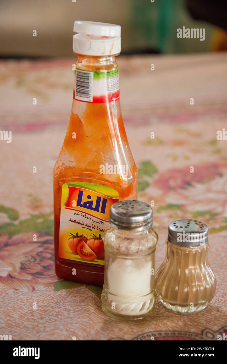 Topf mit Tomatensauce, Salz und Pfeffer in einem gambischen Restaurant Stockfoto