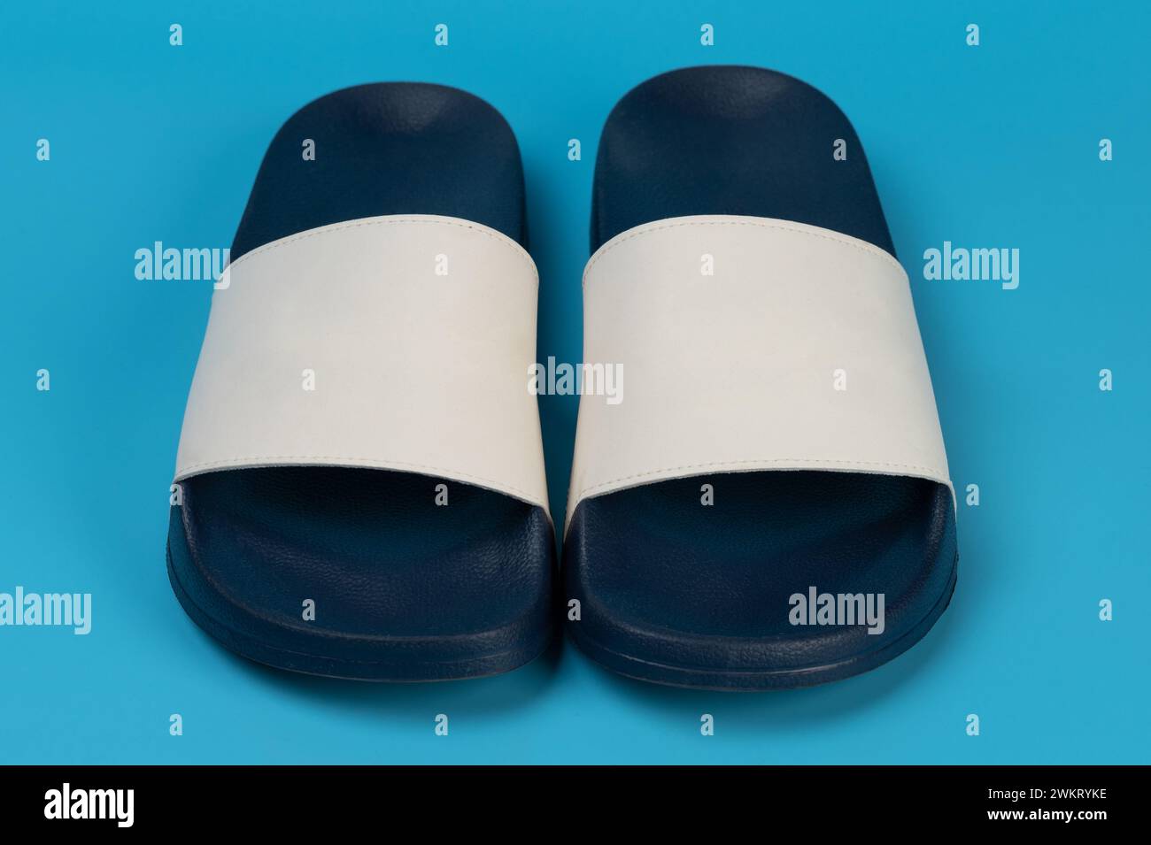 Vorderansicht der bunten Flipflops isoliert auf blauem Stduio-Hintergrund Stockfoto