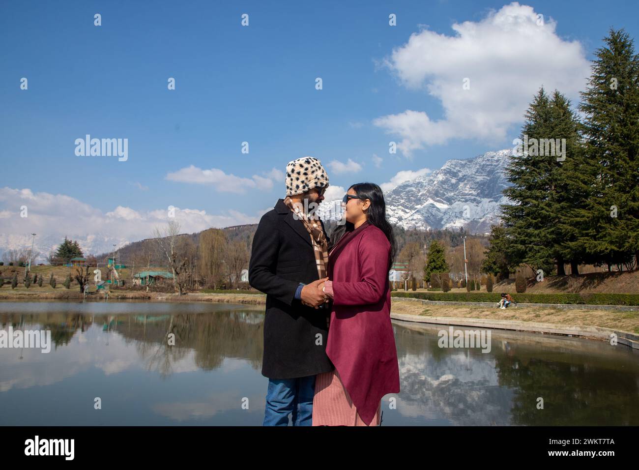 Ein indisches Touristenpaar posiert für ein Foto in einem Garten an einem sonnigen Tag in Srinagar. Das Wetter verbesserte sich in Jammu und Kaschmir nach drei Tagen unaufhörlichen Regens und Schneefall. Währenddessen verbesserten sich die Temperaturen tagsüber mit hellem Sonnenschein, der in vielen Teilen des Tals beobachtet wurde, einschließlich der Sommerhauptstadt Srinagar. Der Dal-See ist nicht nur die wichtigste Touristenattraktion, sondern auch die Heimat von über sechzigtausend Menschen, deren Haupteinkommensquelle aus Tourismus und Landwirtschaft stammt. Stockfoto